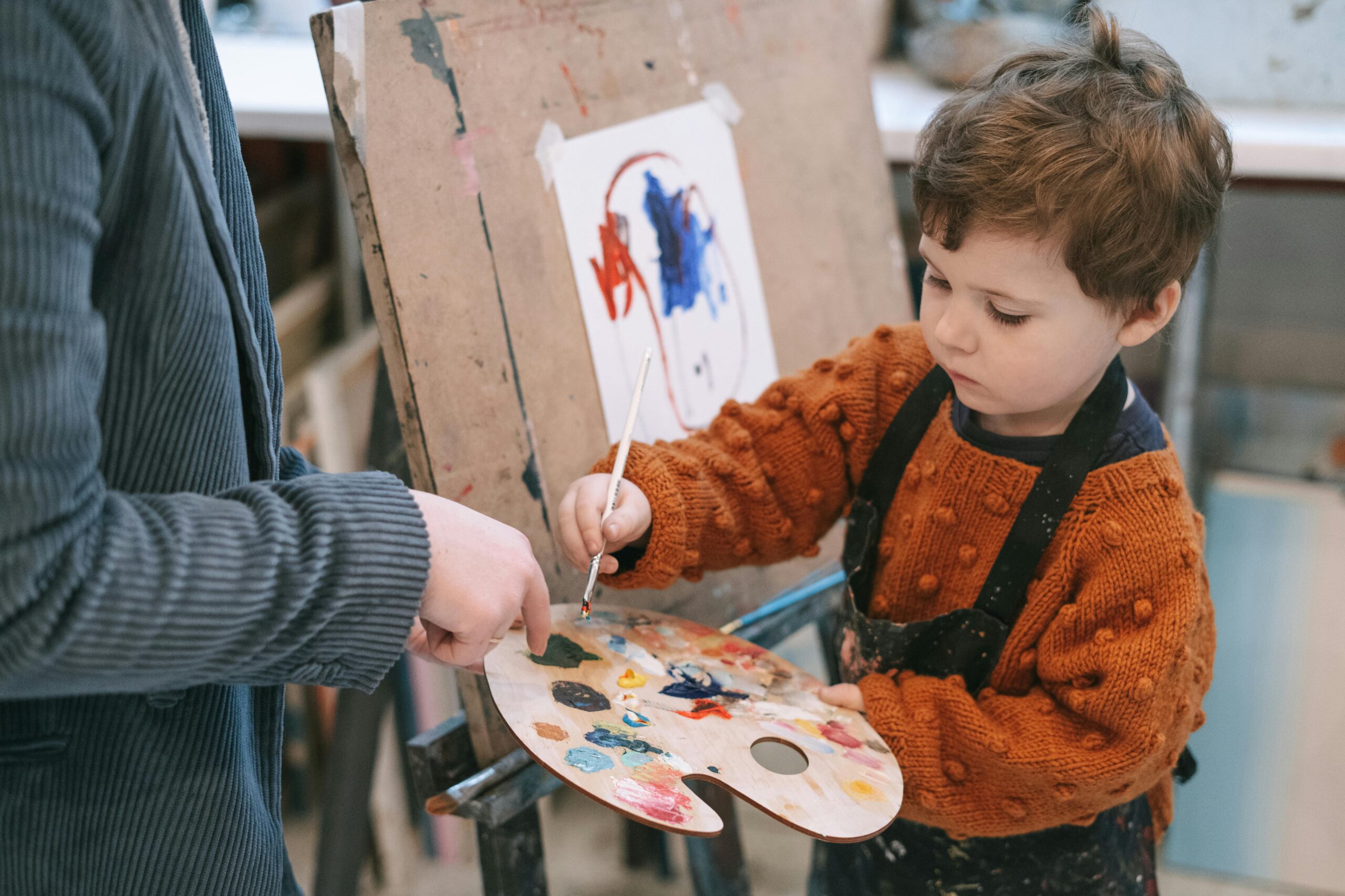 Little boy painting at school