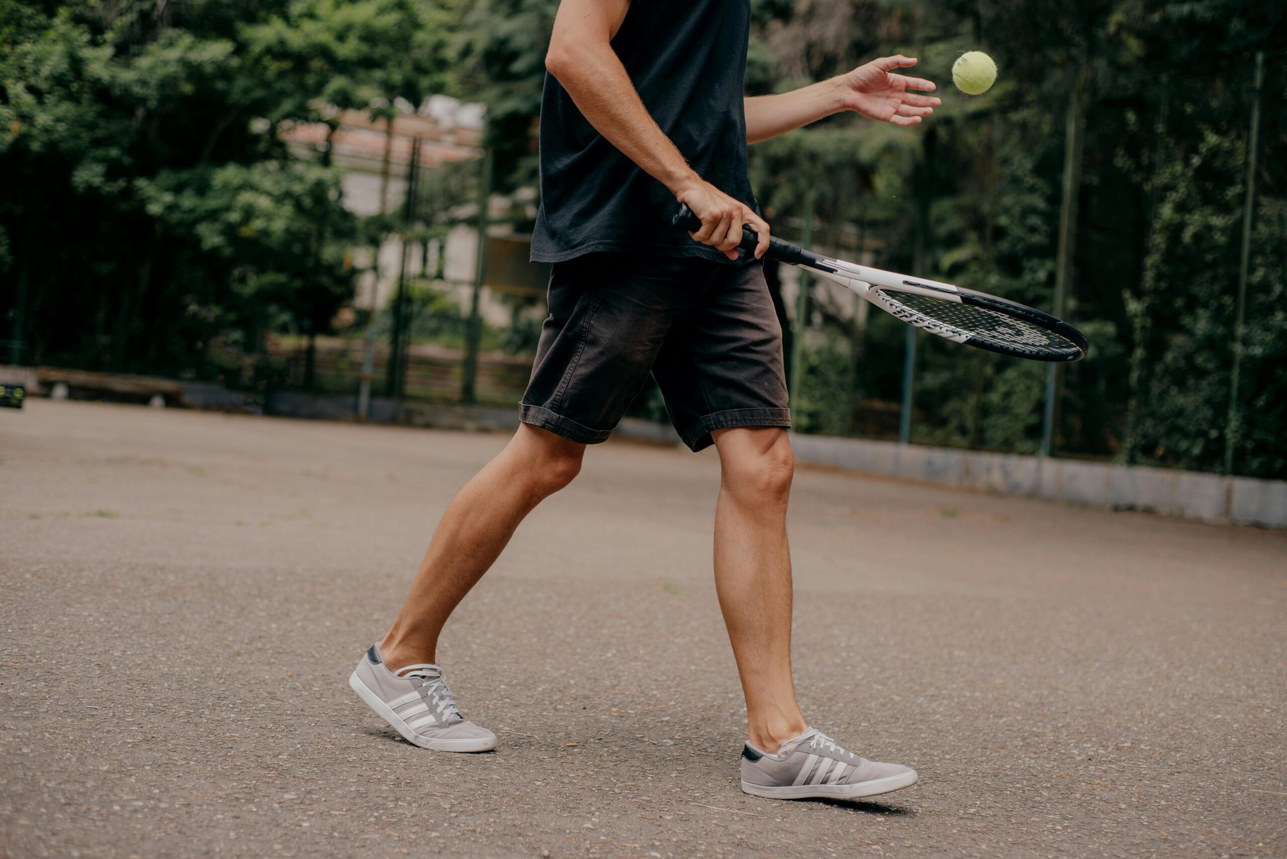 Person playing tennis in a park