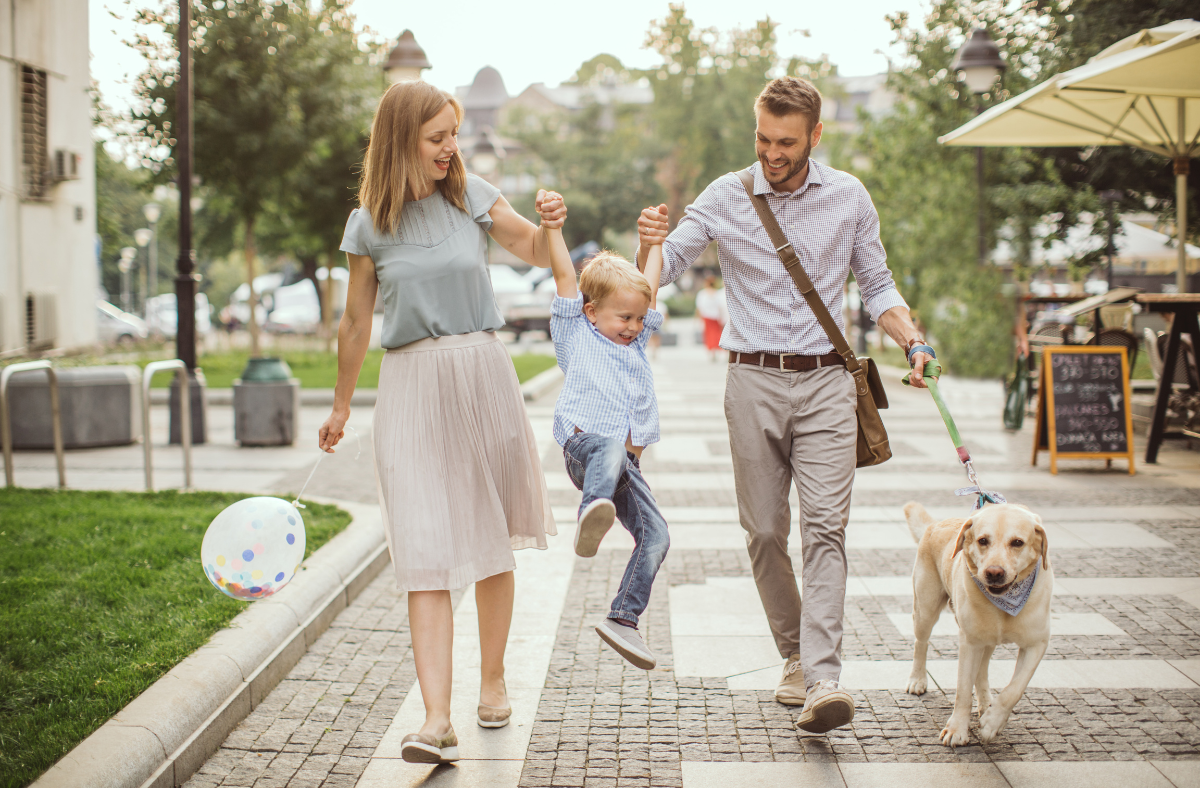 Family walking in the city with their child and dog