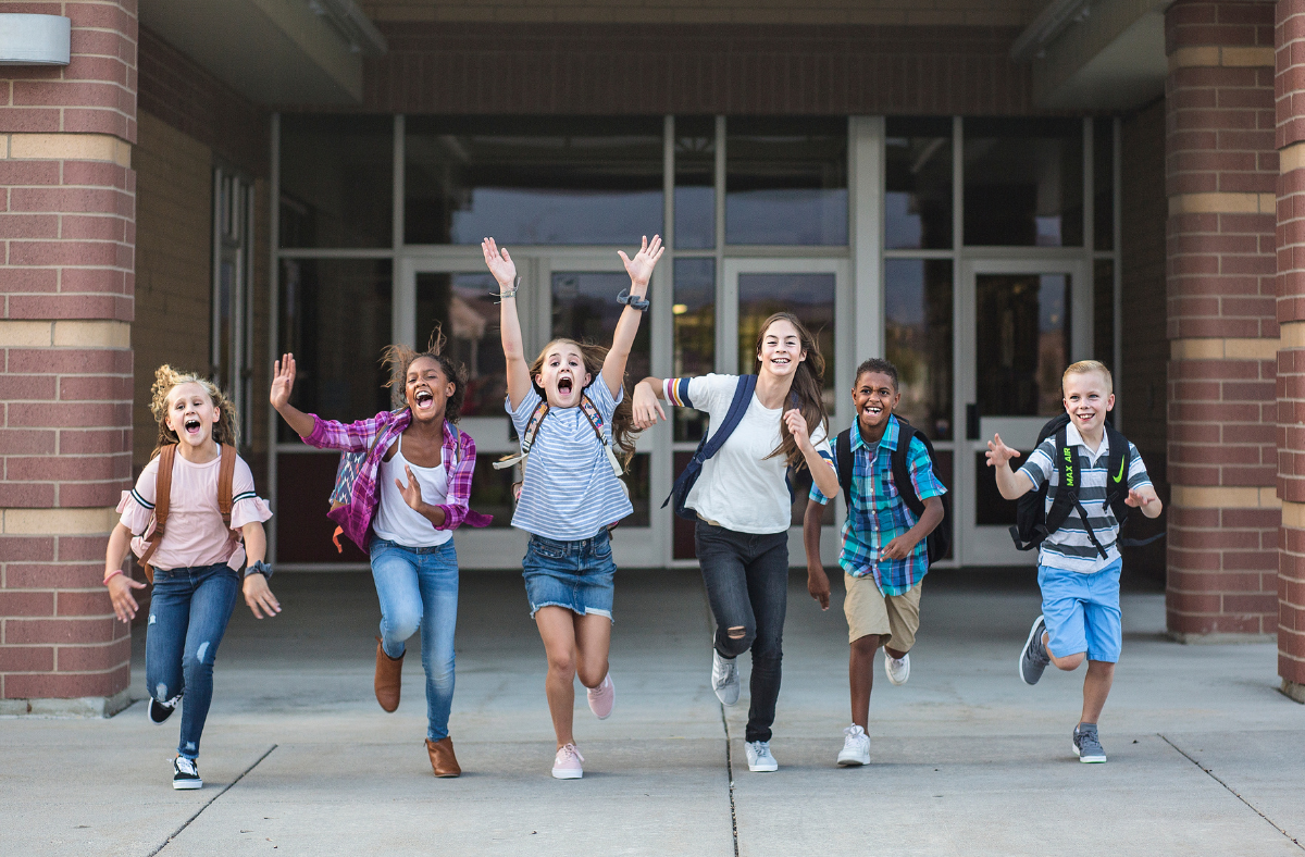 Kids celebrating in front of a school