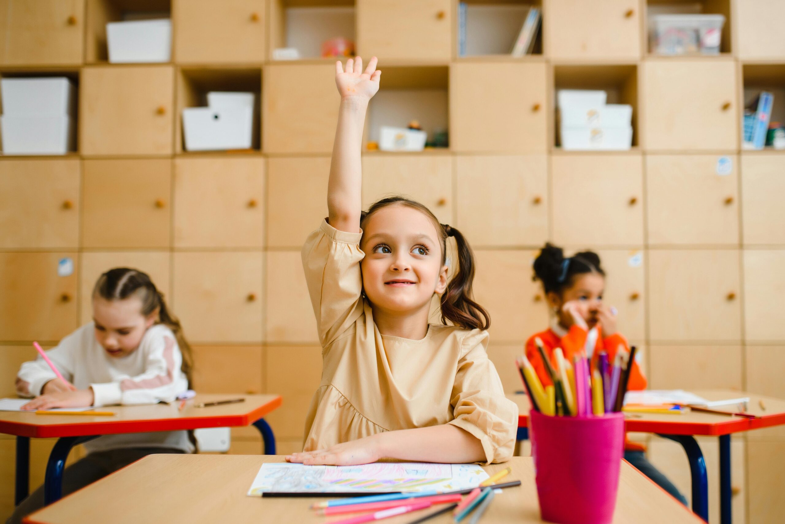 Child raising hand in classroom
