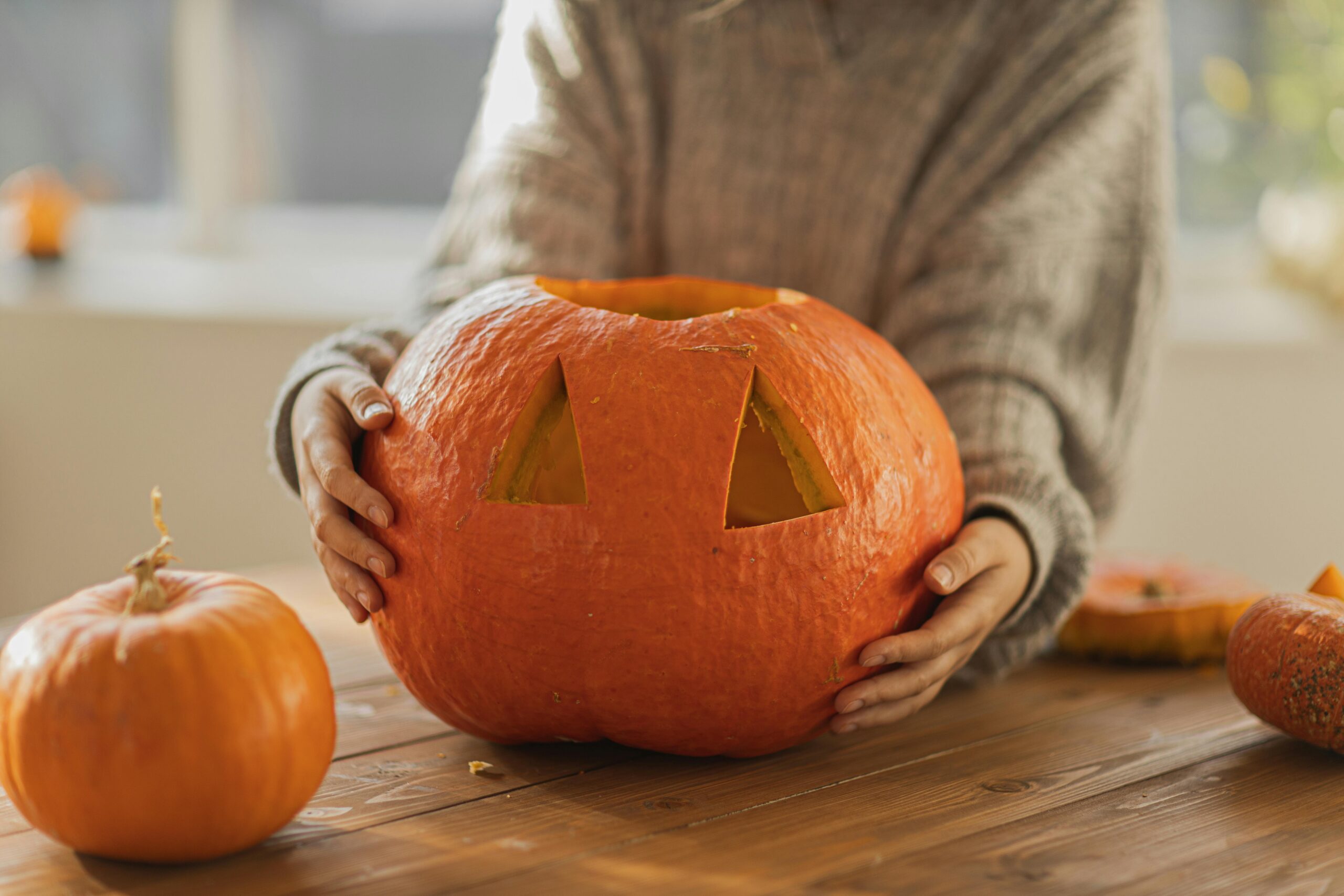 Person carving a pumpkin on a table