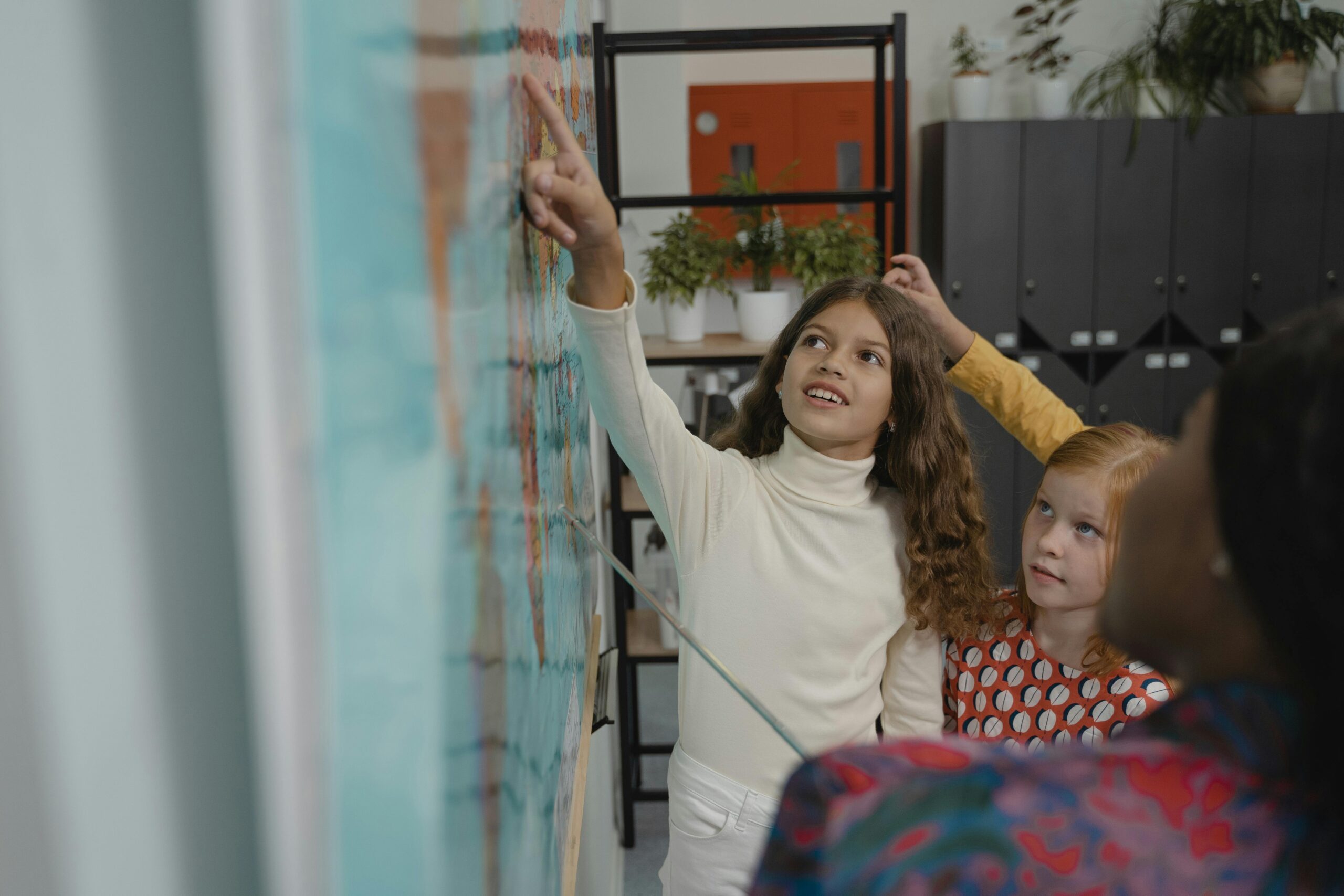 Children at school pointing to a map
