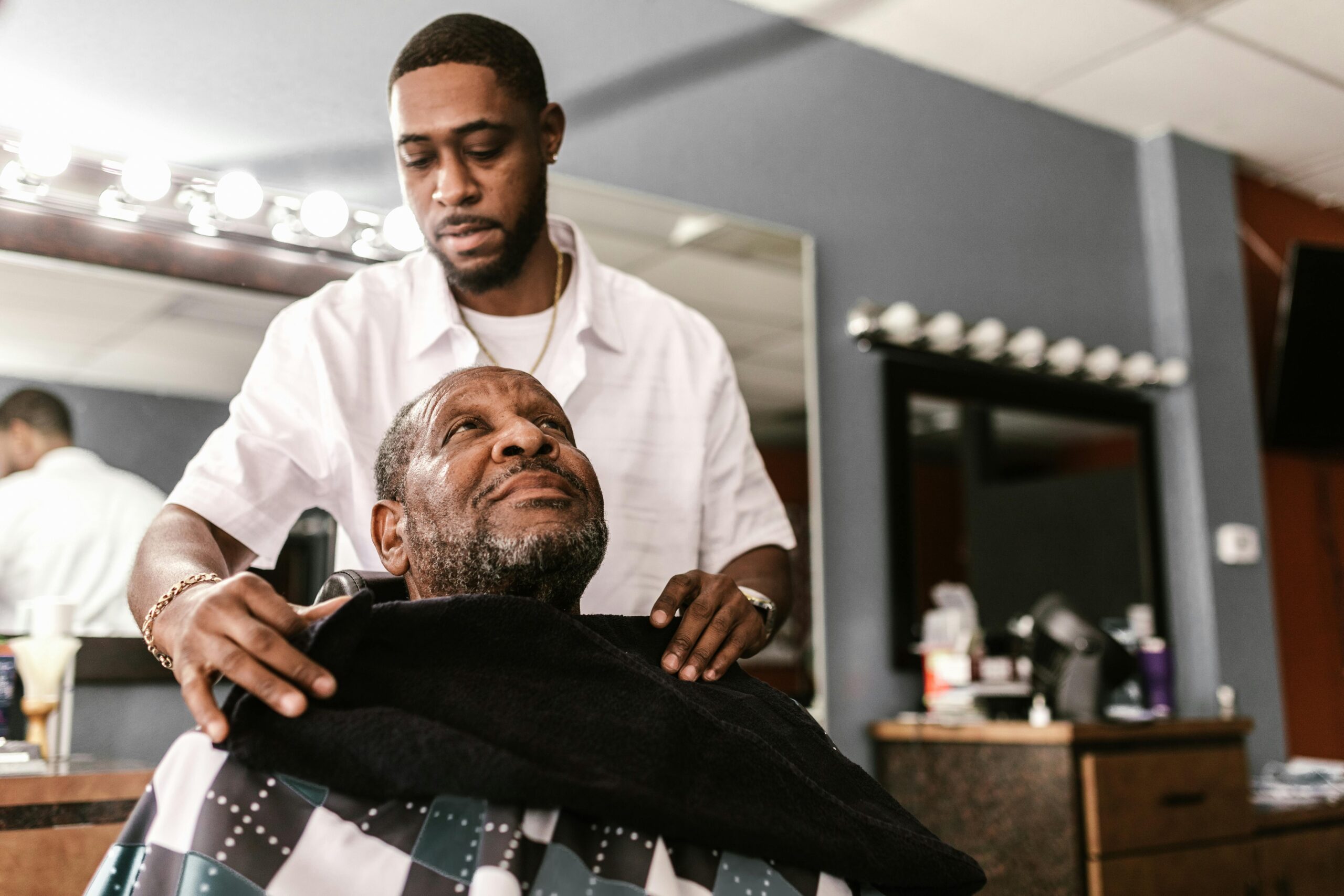 A man in a barbershop getting ready for a haircut.