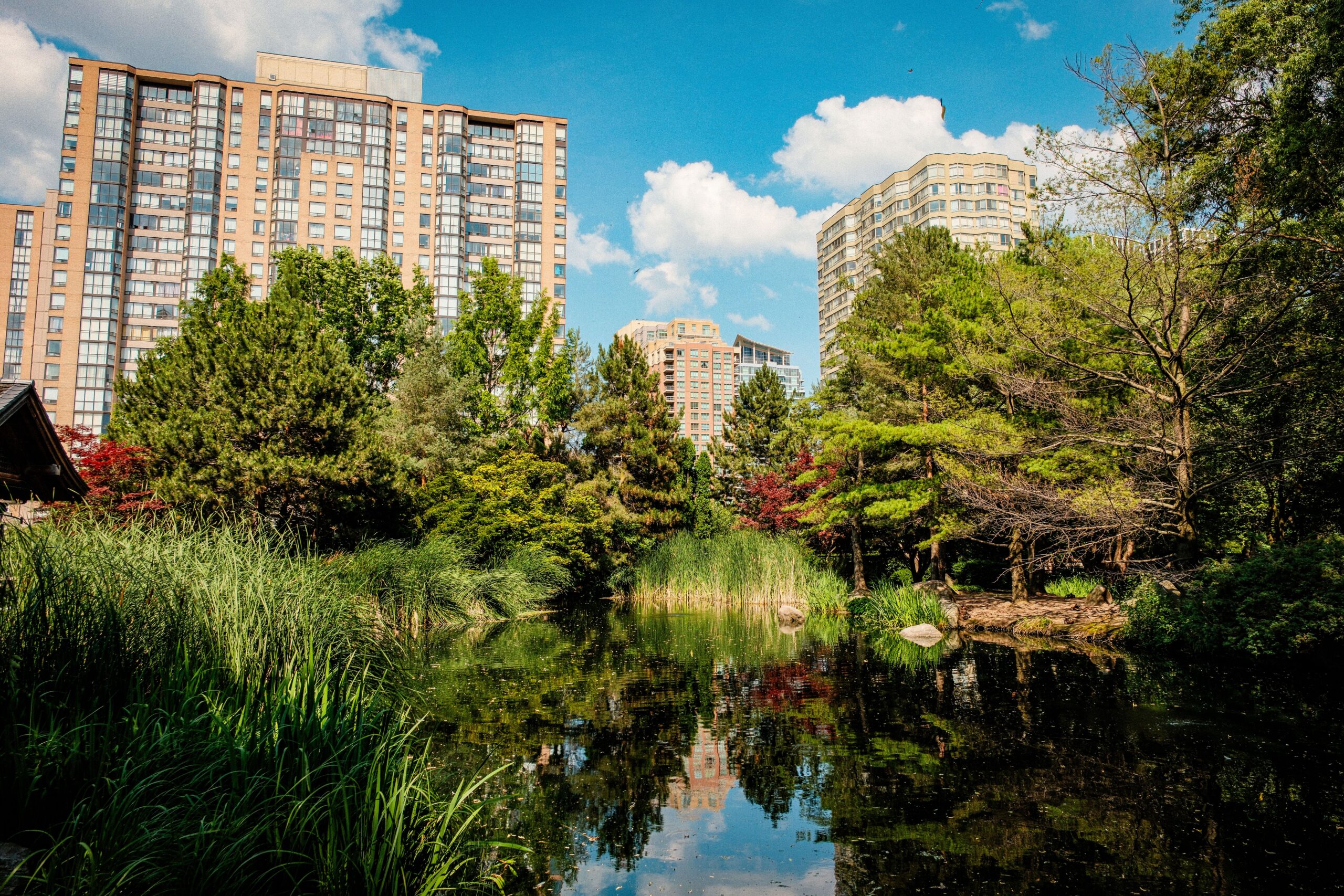 Apartment building near a park with a pond in Victoria Village Toronto
