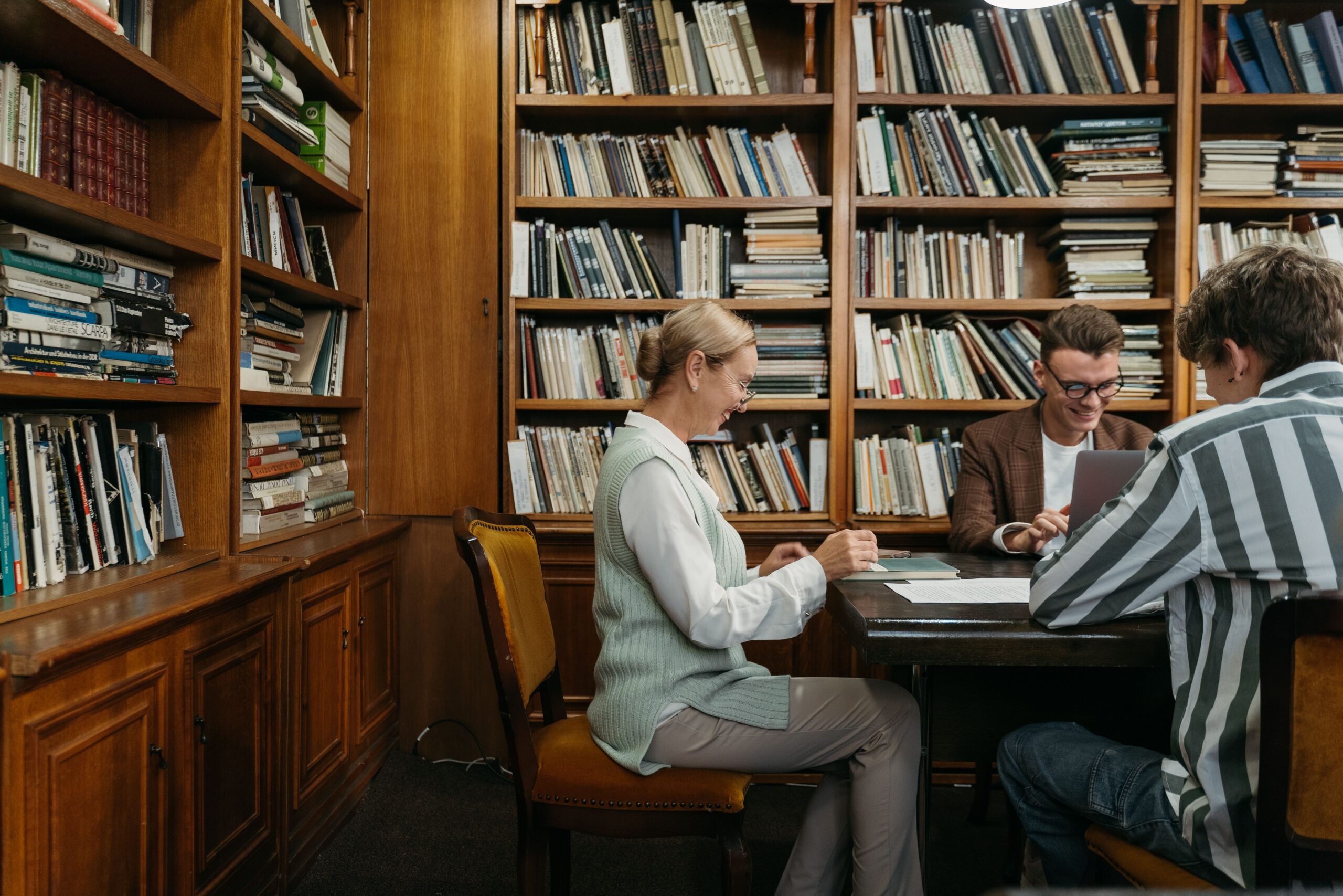 two people sitting in a library at a table.