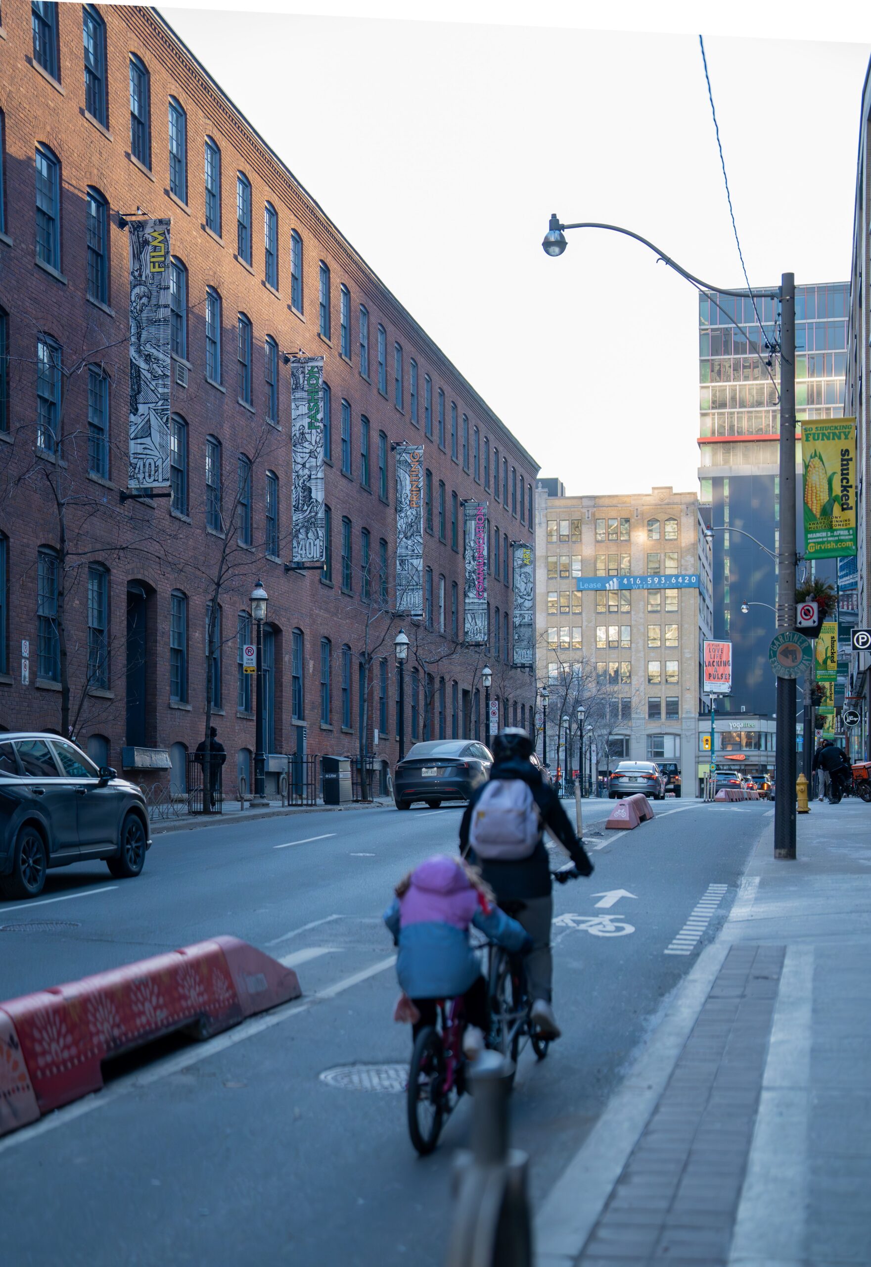 People riding bikes in a cycling lane in a city setting.