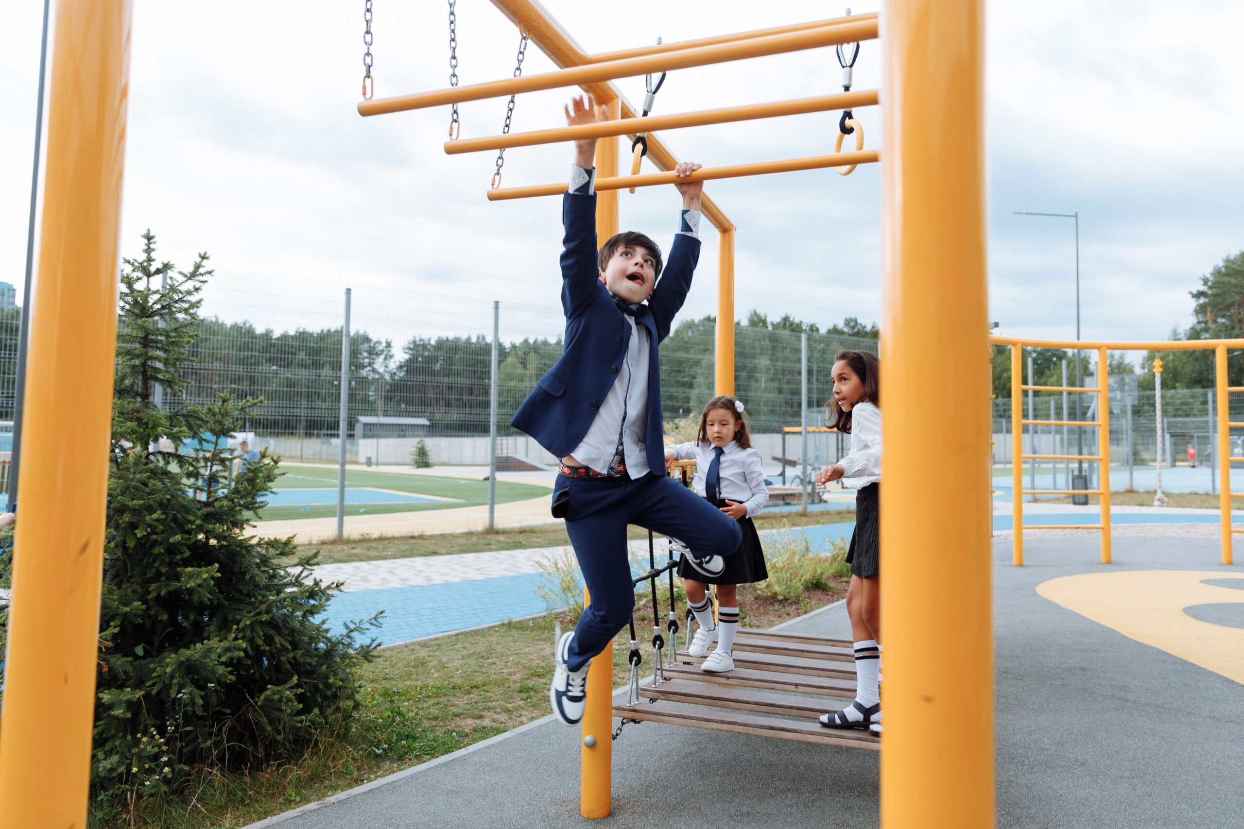 Kids playing on monkey bars at recess.